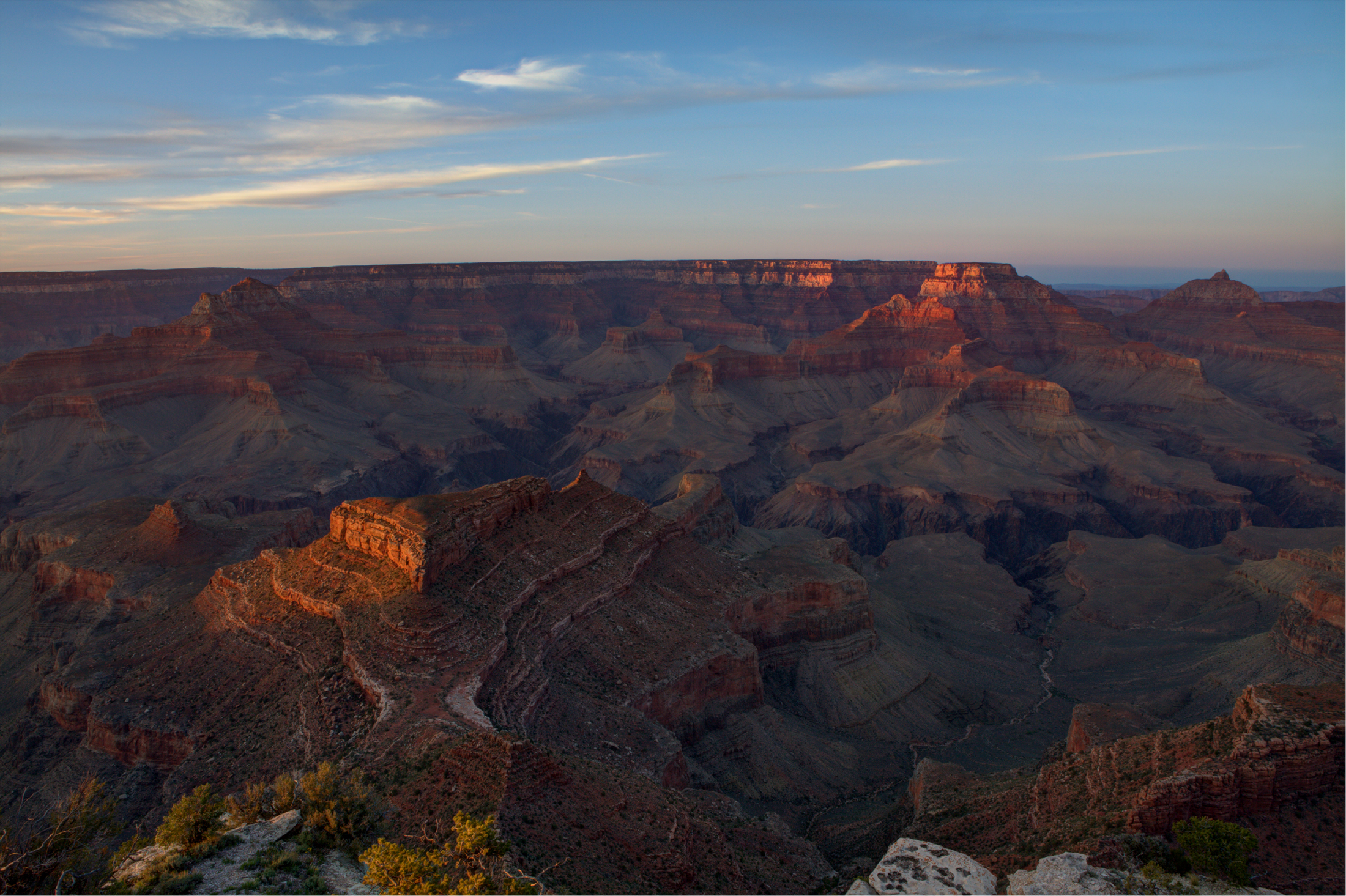 Sunset over the Grand Canyon from Shoshone Point, with warm light illuminating the canyon cliffs.